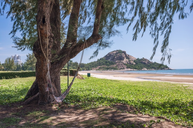 Hammock hanging on tree with Khao Takiab mountain and the beach at Hua Hin, Prachuap Khiri Khan