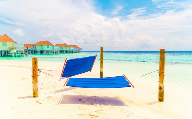 hammock swing around the beach sea and ocean with blue sky white cloud for vacation travel