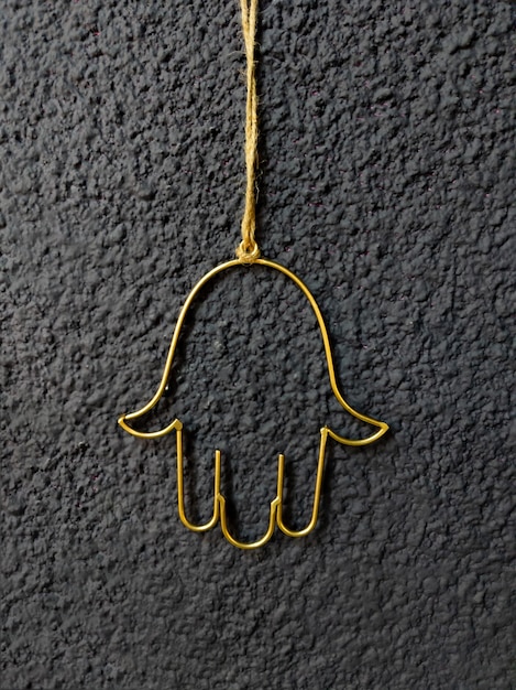 Photo hamsa amulet in the form of an open palm gilded on a dark wall