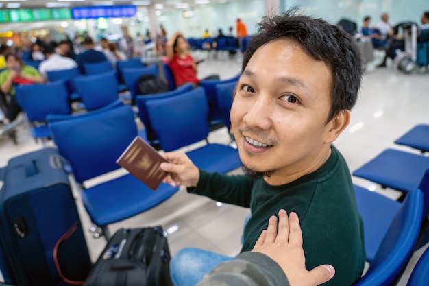 Hand aanraken van de Aziatische schouder voor groet vriend op de luchthaven bij het wachten vlucht aan boord