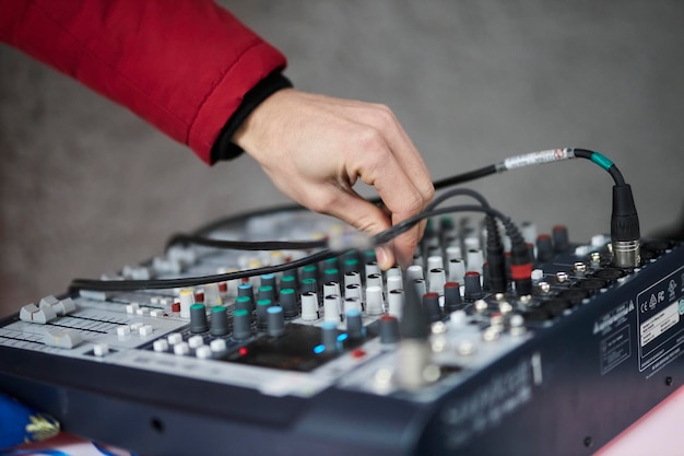 Hand adjusting audio mixer sound engineer hands working on sound mixer in live concert