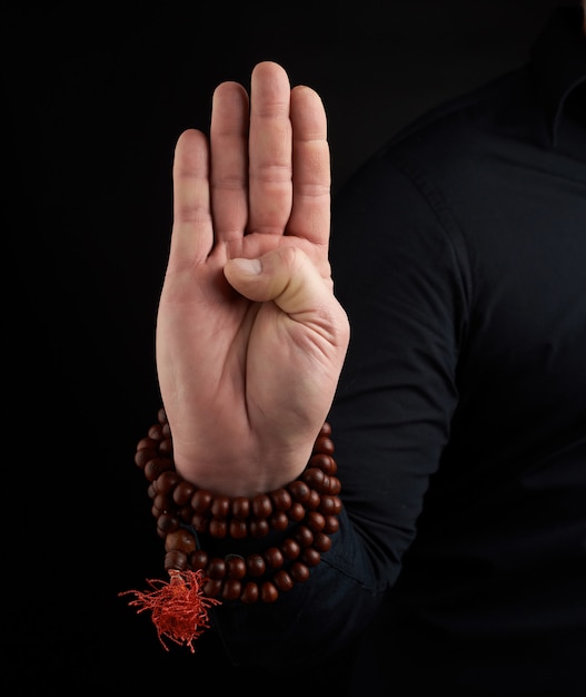 Hand of an adult male shows mudra 