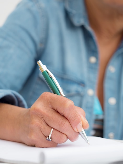 Hand of adult woman writing with pen