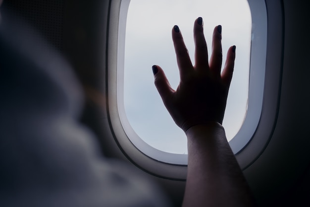 Hand on an airplane window 