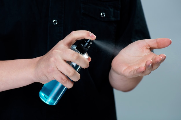 Applicare a mano alcool o spray antibatterico per prevenire la diffusione di germi, batteri e virus. igiene personale. concetto di disinfezione del coronavirus covid-19