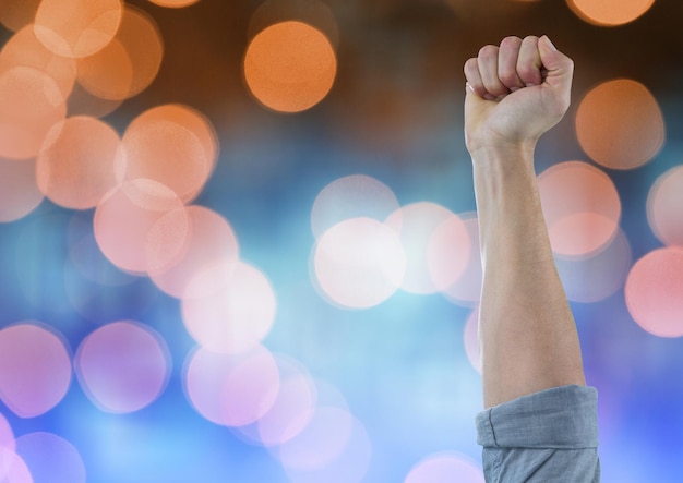 Hand arm celebrating with fist and sparkling light bokeh background