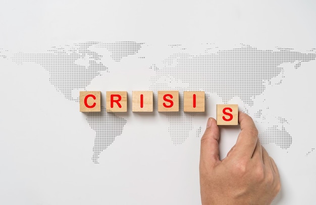 Hand arrang red crisis wording on world map for world crisis concept from epidemic disease and economic recession