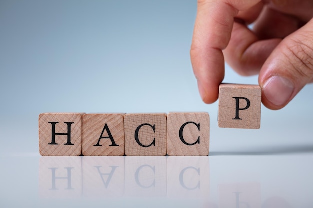 Photo hand arranging haccp letters