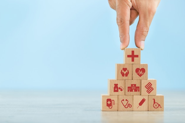 hand arranging wood block stacking with icon healthcare medical.