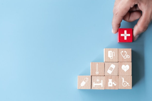 Photo hand arranging wood block stacking with icon healthcare medical