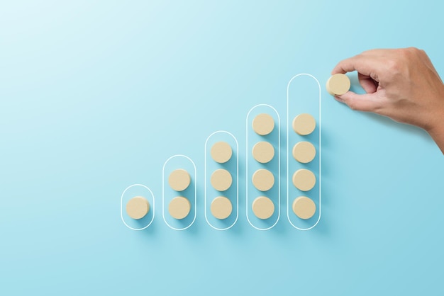 Hand arranging wood block on top step ladder career path\
concept for business growth success process