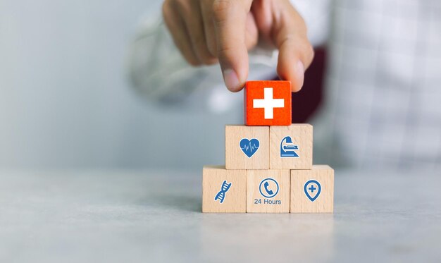 Foto sistemazione a mano blocco di legno con icona medica sanitaria. concetto di assicurazione sanitaria.
