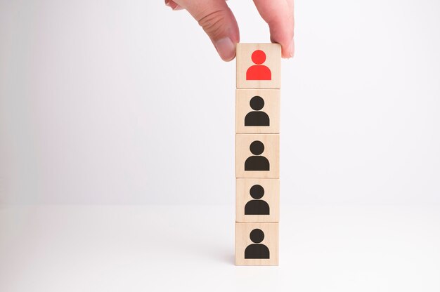 白い背景の上の列として積み重ねる木製のブロックを手で配置します。