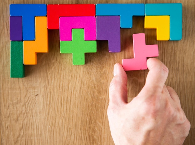 Hand arranging wooden blocks