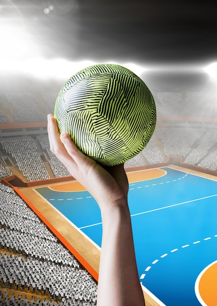 Photo hand of athlete holding ball against stadium background