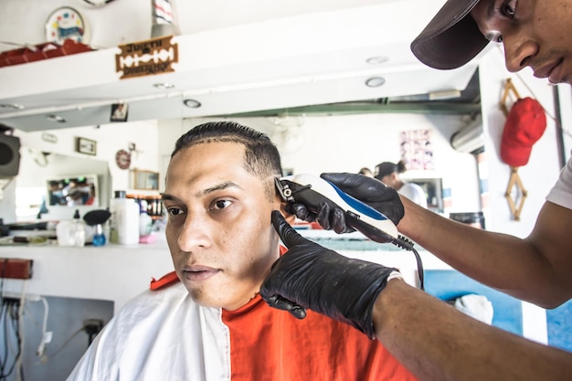 Hand of a barber cutting the hair of a costumer