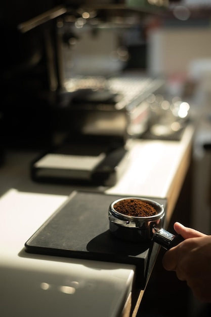 Photo hand of barista holding a coffee tamper