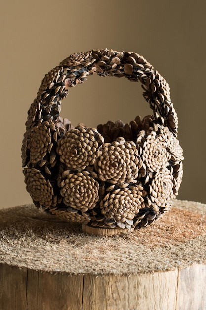 Hand basket made of pine cones placed on log