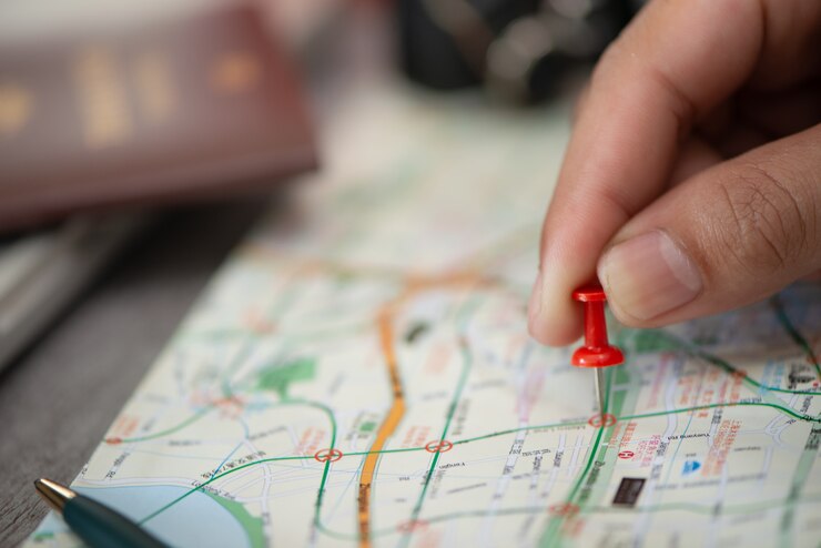 Hand bij het richten van rood speldplan om op kaart te reizen, reisconcept