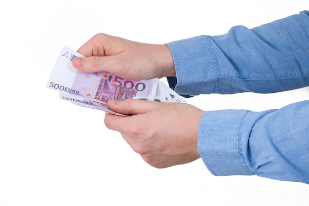 Hand In blue shirt hold euros banknotes on white background. Isolated.