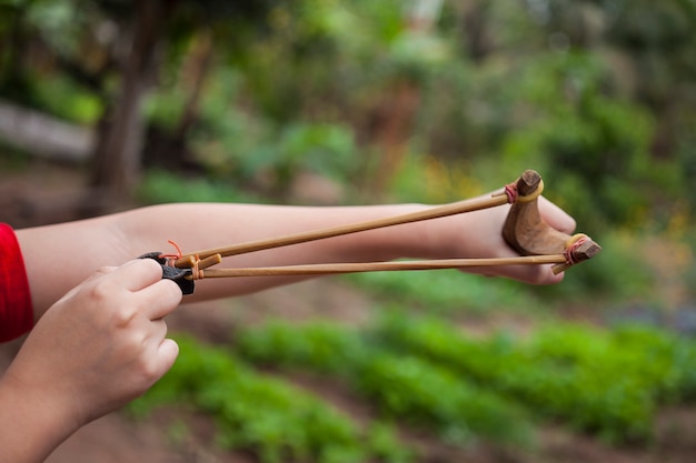 Hand boy pulling sling shot