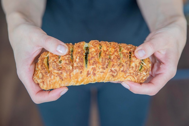 A hand breaks a spinach bun in half closeup eating quick snacks