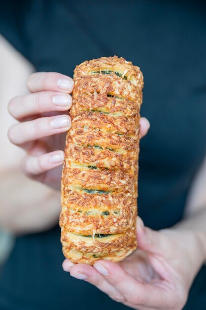 A hand breaks a spinach bun in half closeup eating quick snacks