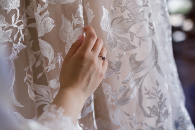 Hand of the bride on a wedding dress