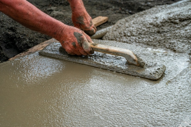 Hand builder with trowel leveling concrete