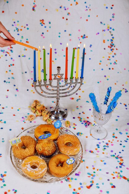 Hand burning candles Menorah on wooden