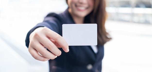 テキストの空の白いカードを保持しているビジネス女性の手