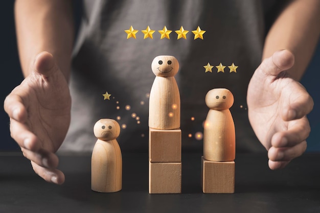 Hand of a businessman chooses a smiley face on wooden peope 5 Star Satisfaction