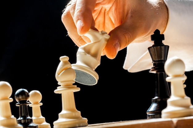 Hand of businessman playing chess