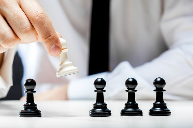 Hand of businessman playing chess