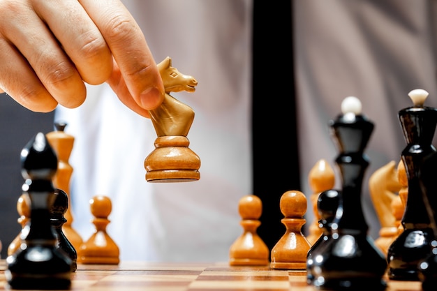 Hand of businessman playing chess