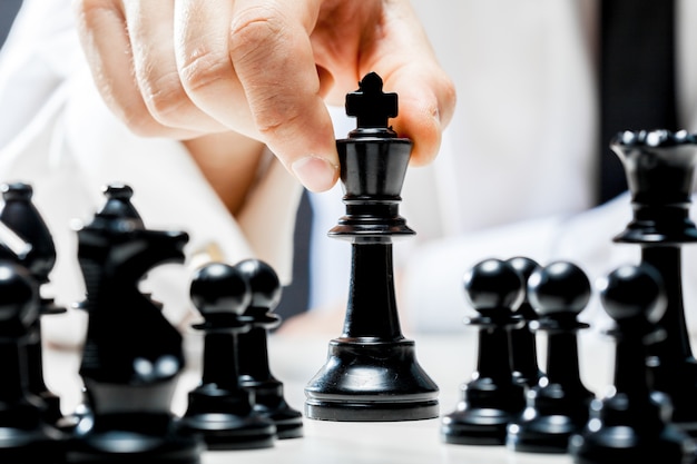 Hand of businessman playing chess