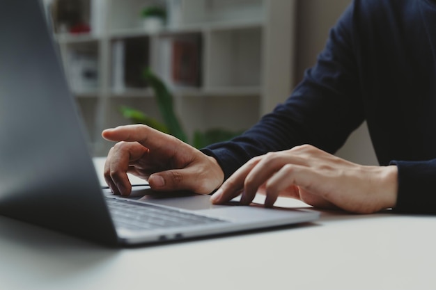 Hand of businessman pointing to laptop screen at home office work process and social network concept