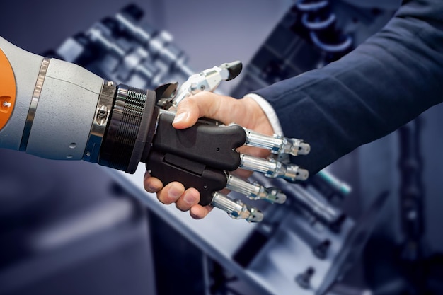 안드로이드 로봇과 악수하는 사업가의 손. 인공 지능과 인간의 상호 작용의 개념.