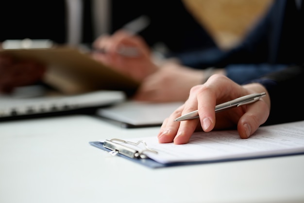 Hand of businessman signing document with pen