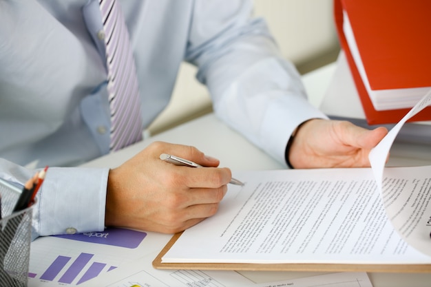 Hand of businessman in suit filling closeup