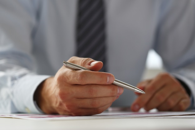 Hand of businessman in suit filling and signing with