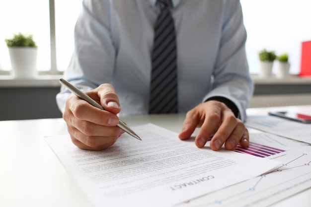 Hand of businessman in suit filling and signing with