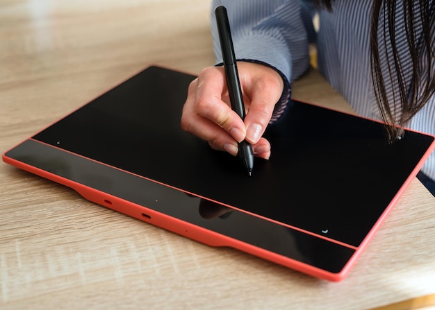 Рука деловой женщины рисует цифровой ручкой на графическом планшете
