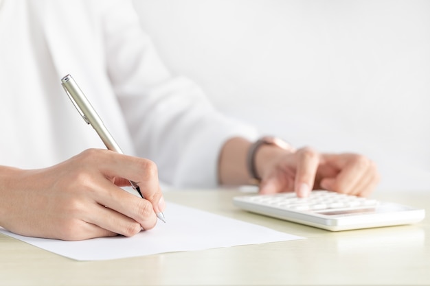 Hand of businesswoman writing on paper in the office