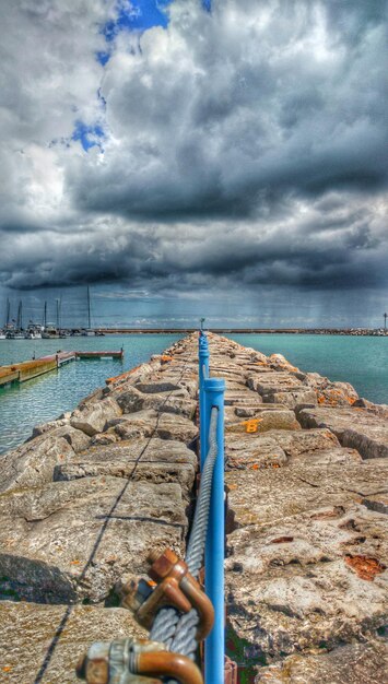 Photo hand by sea against sky