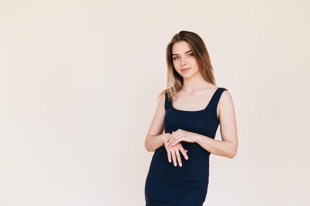 Hand care Woman Stands Posing on Beige Background in Black Dress Perfect Wellgroomed Skin