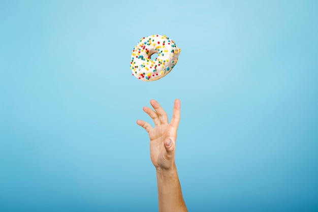 Hand catch a donut with icing. concept of baking, handmade.\
flat lay, top view