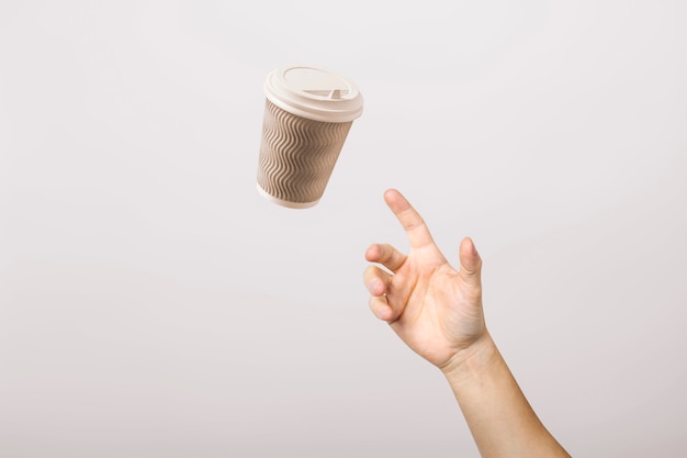 Hand catches a cardboard glass on a light cardboard