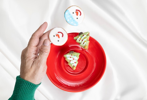 A hand catching  a falling plate of christmas sugar biscuits.