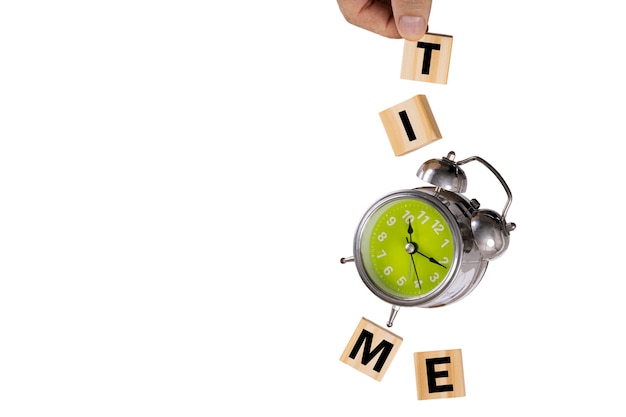 A hand catching a falling rusty old alarm clock and four wooden cubes